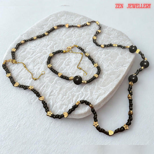 Several larger round black agate beads serve as focal elements within the necklace and bracelet design. These statement stones add depth, dimension, and luxury while maintaining a cohesive appearance with the smaller surrounding beads. The photograph captures the smooth rounded shapes and glossy finish of the gemstones, allowing buyers to visualize the premium quality and elegant character of the handcrafted jewellery.