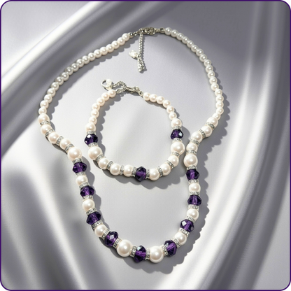 A pearl-bead necklace and matching bracelet with faceted purple crystal accents and silver-tone hardware, arranged on a satin-like silver background.