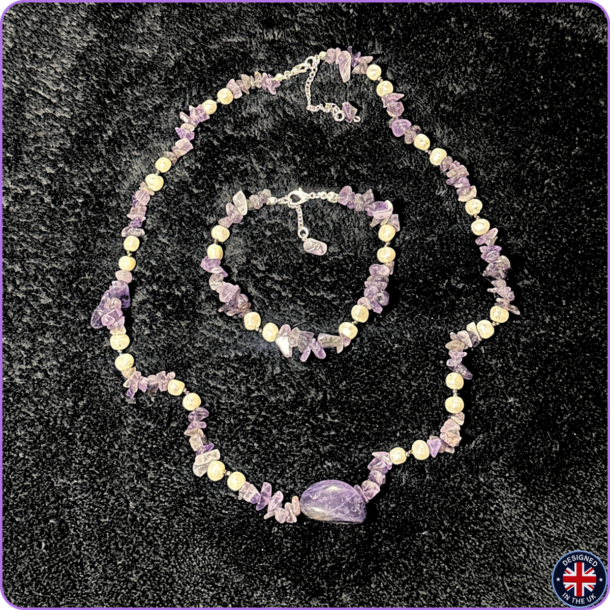 Amethyst crystal jewelry set including a necklace and bracelet, displayed on a black textured background. The jewelry features light purple amethyst chips, lavender beads, and a larger polished purple stone centerpiece on the necklace.