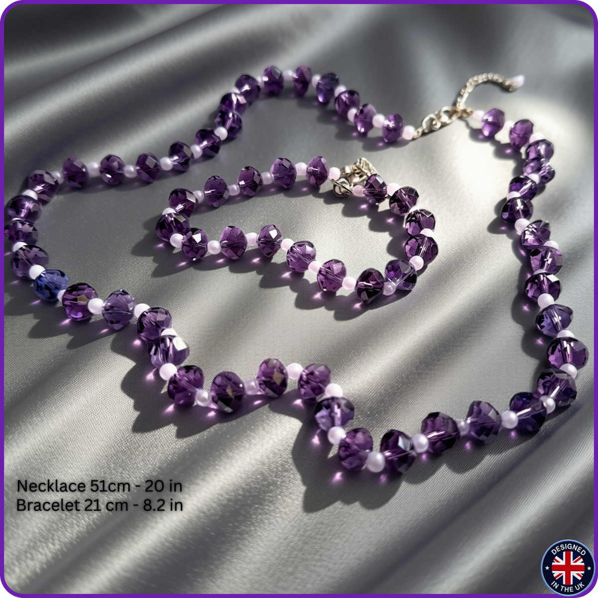 Purple crystal and white bead necklace and bracelet set on a shiny silver satin background, with text showing measurements and a small UK made badge.