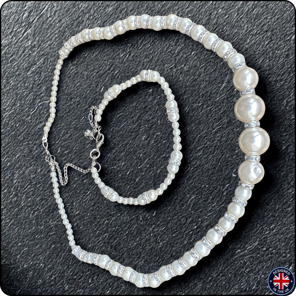 A pearl beaded necklace and matching bracelet set on a dark textured background. The beads are white with a lustrous pearl finish, separated by silver-toned spacer beads, and the necklace has an adjustable silver clasp.