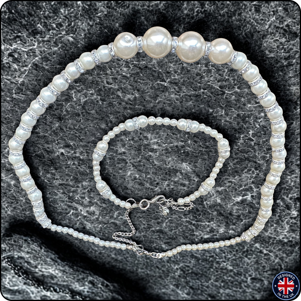 A pearl jewelry set consisting of a choker necklace and a matching bracelet, both featuring white freshwater-style pearls and silver-toned spacer beads, displayed on a dark gray textured stone background.