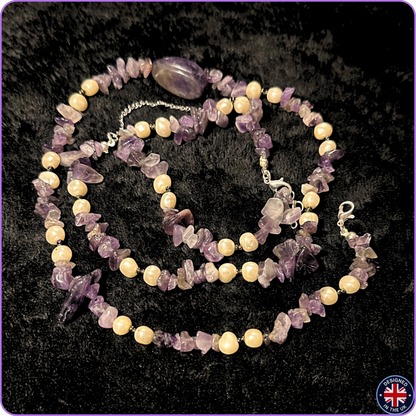 A beaded necklace and matching bracelet made of purple amethyst chip stones and cream-colored round beads, displayed on a black textured background.