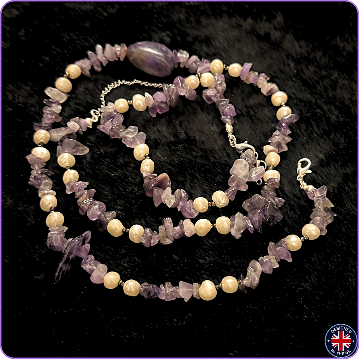 A beaded necklace featuring light cream-colored round pearls and lavender-purple translucent stone chips, with a polished oval purple bead and silver-tone clasp, displayed on a black textured background.