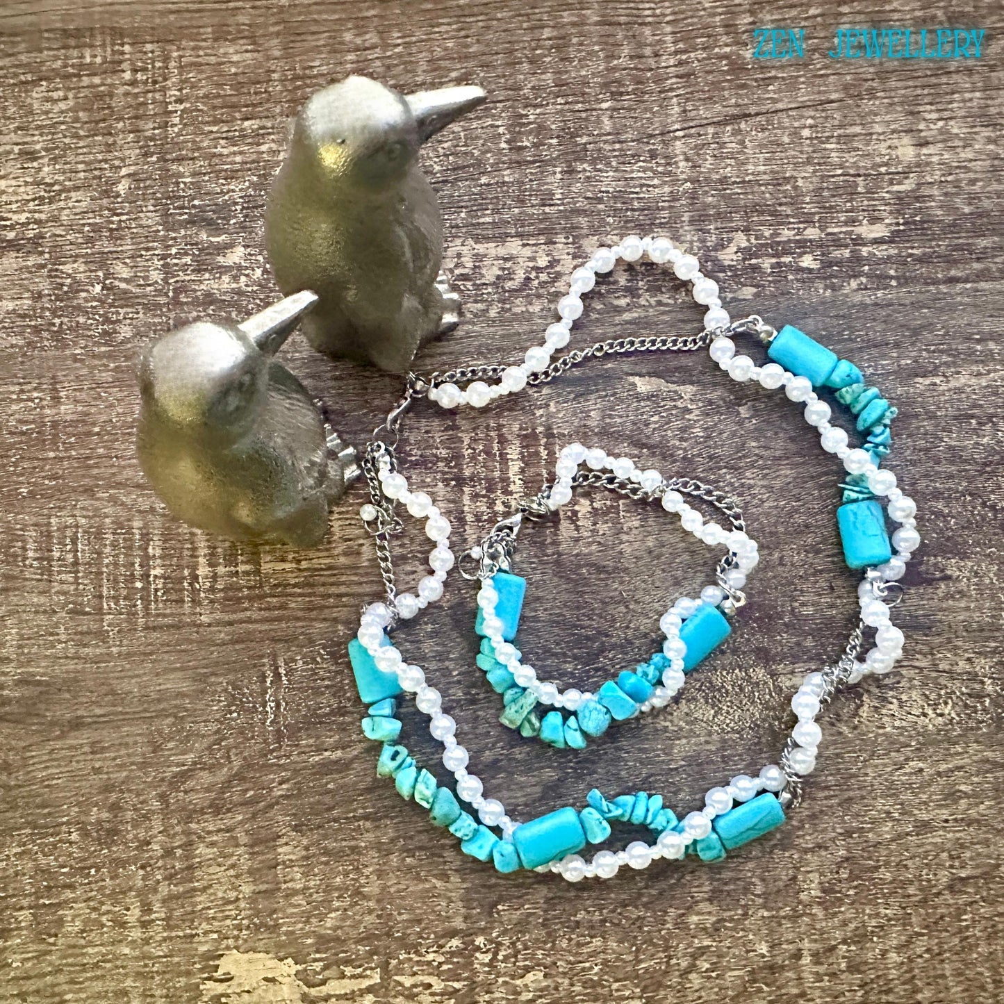 Turquoise and pearl necklace set styled for a bohemian look, soft lighting highlights smooth pearls and textured turquoise chips, the necklace positioned around the neckline and bracelet at the centre showing a matching design and wearable size.
