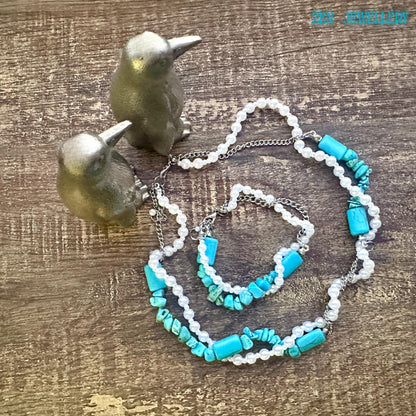 Turquoise and pearl necklace set styled for a bohemian look, soft lighting highlights smooth pearls and textured turquoise chips, the necklace positioned around the neckline and bracelet at the centre showing a matching design and wearable size.