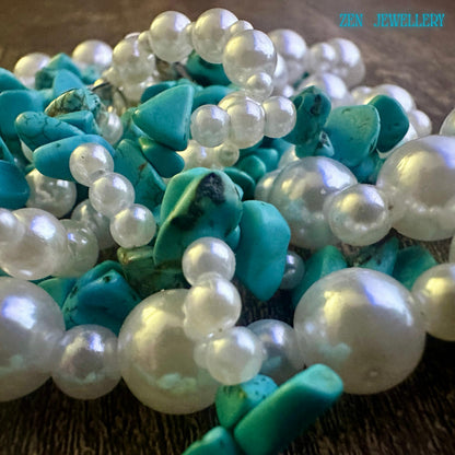 Close up Turquoise stones with natural variations in colour from bright blue to green tones, combined with creamy pearl beads.