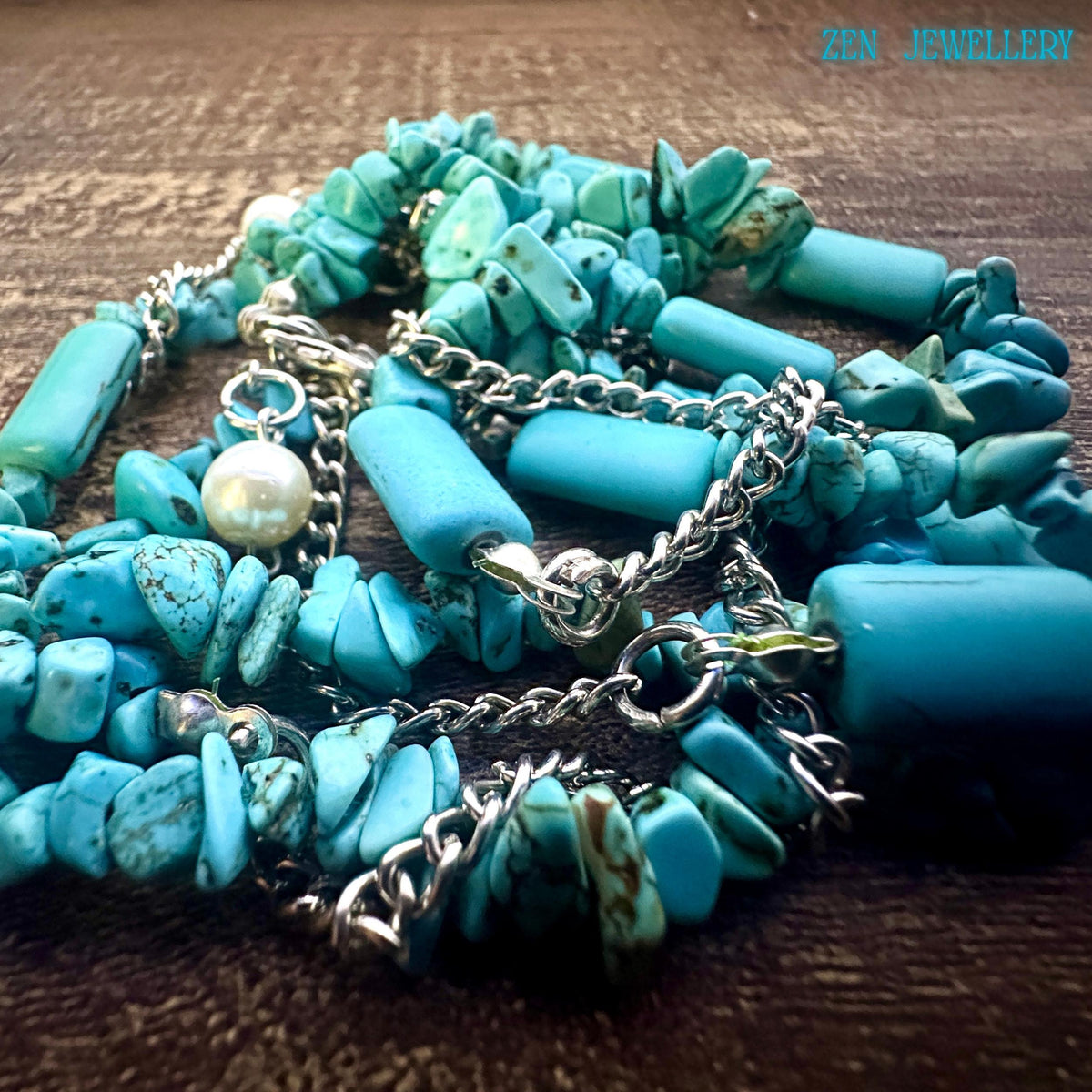 Necklace extension chain ending with a small pearl charm, adding refined detail and soft contrast to bold turquoise tones.
Texture-focused image highlighting rough turquoise chips combined with smoother bead shapes for a handcrafted aesthetic.