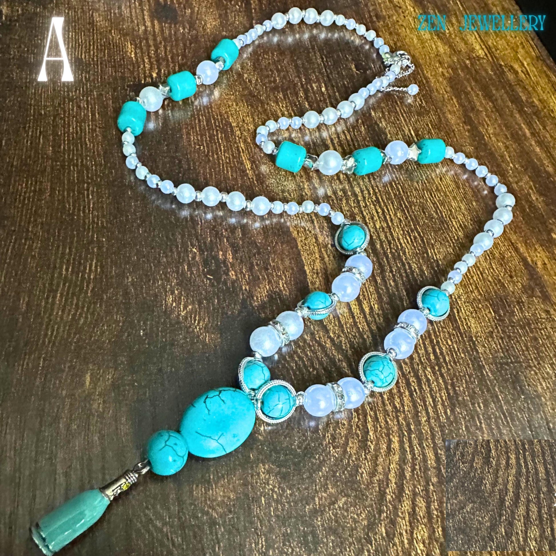A close-up, detailed image of the turquoise beaded necklace showing polished turquoise nuggets combined with luminous pearl beads and silver rhinestone separators. The handcrafted jewellery design reveals natural turquoise veining and glossy pearl reflections against the wooden surface. The sterling silver findings add elegance while the long silhouette gives a timeless bohemian style appearance suitable for daily wear or special occasions.
