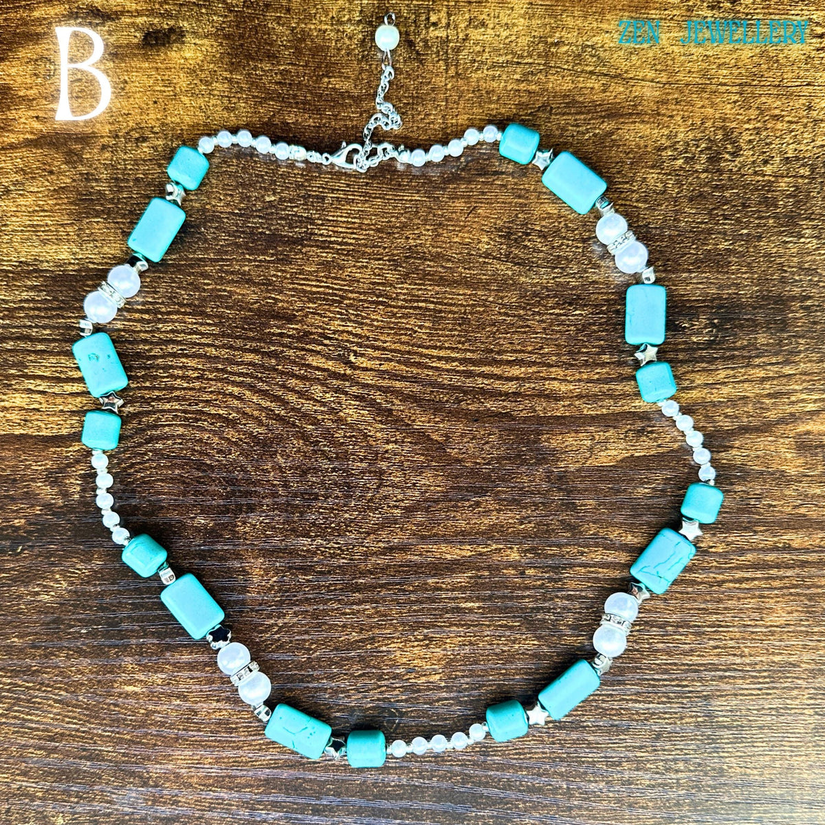 This vintage-inspired turquoise necklace features polished turquoise cabochons framed with silver settings and luminous pearl accents arranged in a sophisticated handcrafted composition. The long necklace shape elegantly curves across a rustic wood table, allowing buyers to appreciate the bead sizes, silver clasp detail, and artisan assembly. The statement tassel pendant enhances the western bohemian aesthetic beautifully.