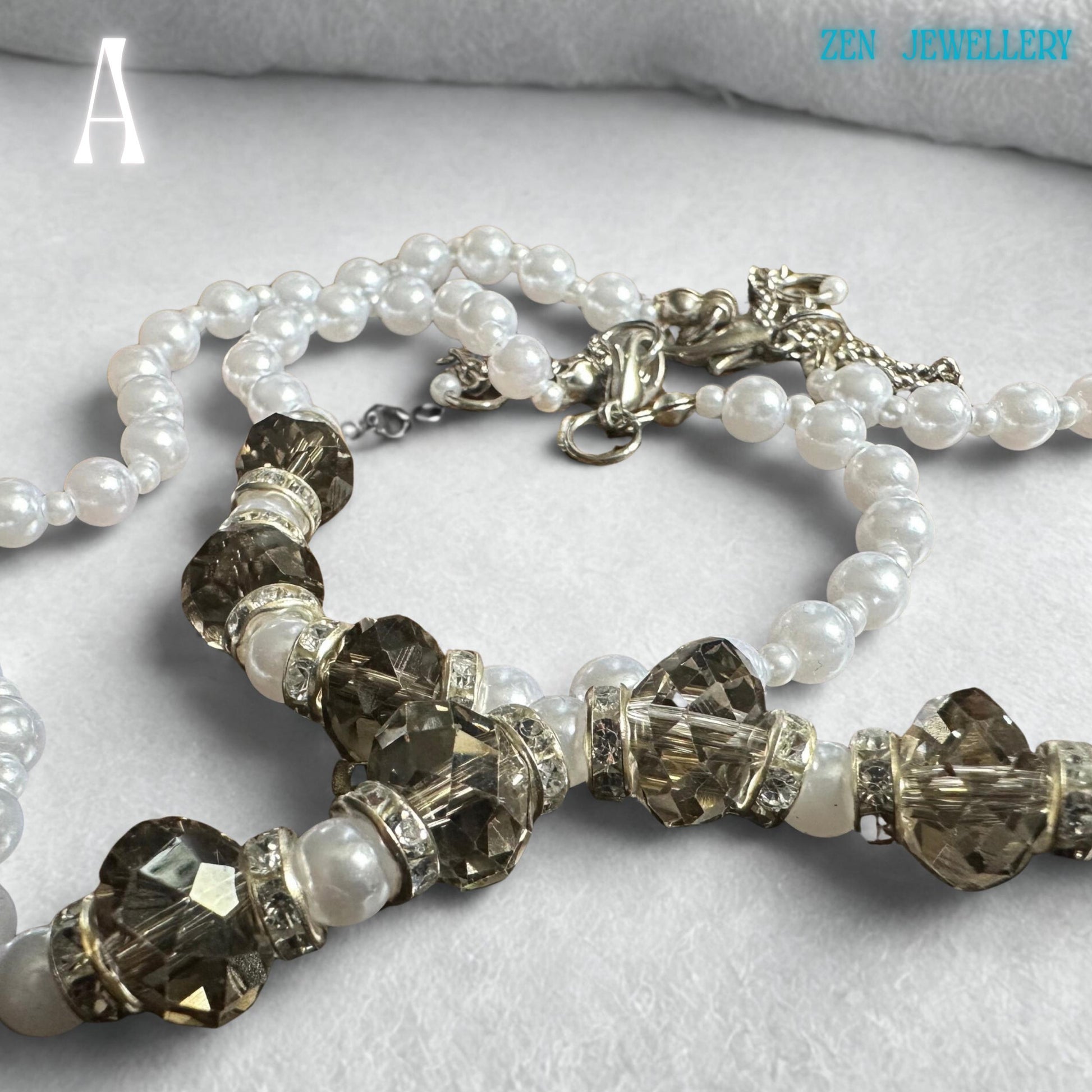 Close-up white pearl necklace with shimmering transparent Austrian crystals layered on a delicate silver chain, boho chic style. the perfect gift for a wedding or an anniversary.
