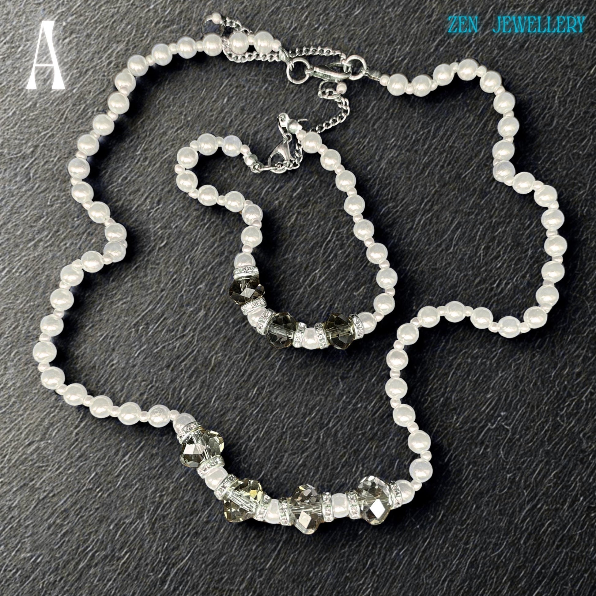 Close-up image of a handmade white pearl jewellery set with faceted grey crystal beads and silver spacer details. The glossy pearl beads reflect light beautifully and create a soft luxurious appearance. The bracelet perfectly matches the necklace and includes sparkling rhinestone spacers that add elegant shine and contrast. The dark background enhances the brightness of the pearls and the sparkle of the crystals.