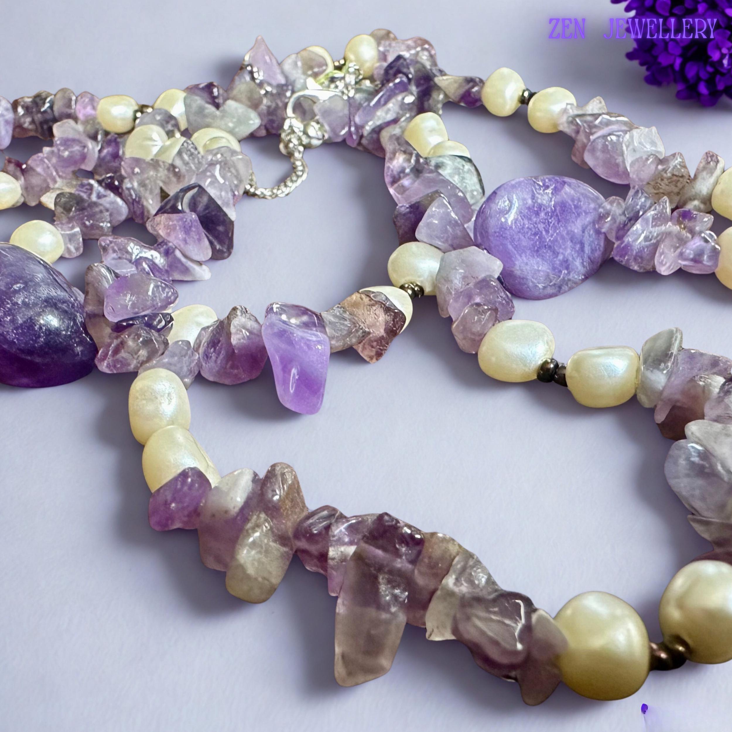 The natural amethyst crystal chips display mixed lavender, violet, and translucent tones with raw organic textures that reflect light softly. Cream pearl-style beads add balance and elegance inspired by classic boho gemstone jewellery collections.