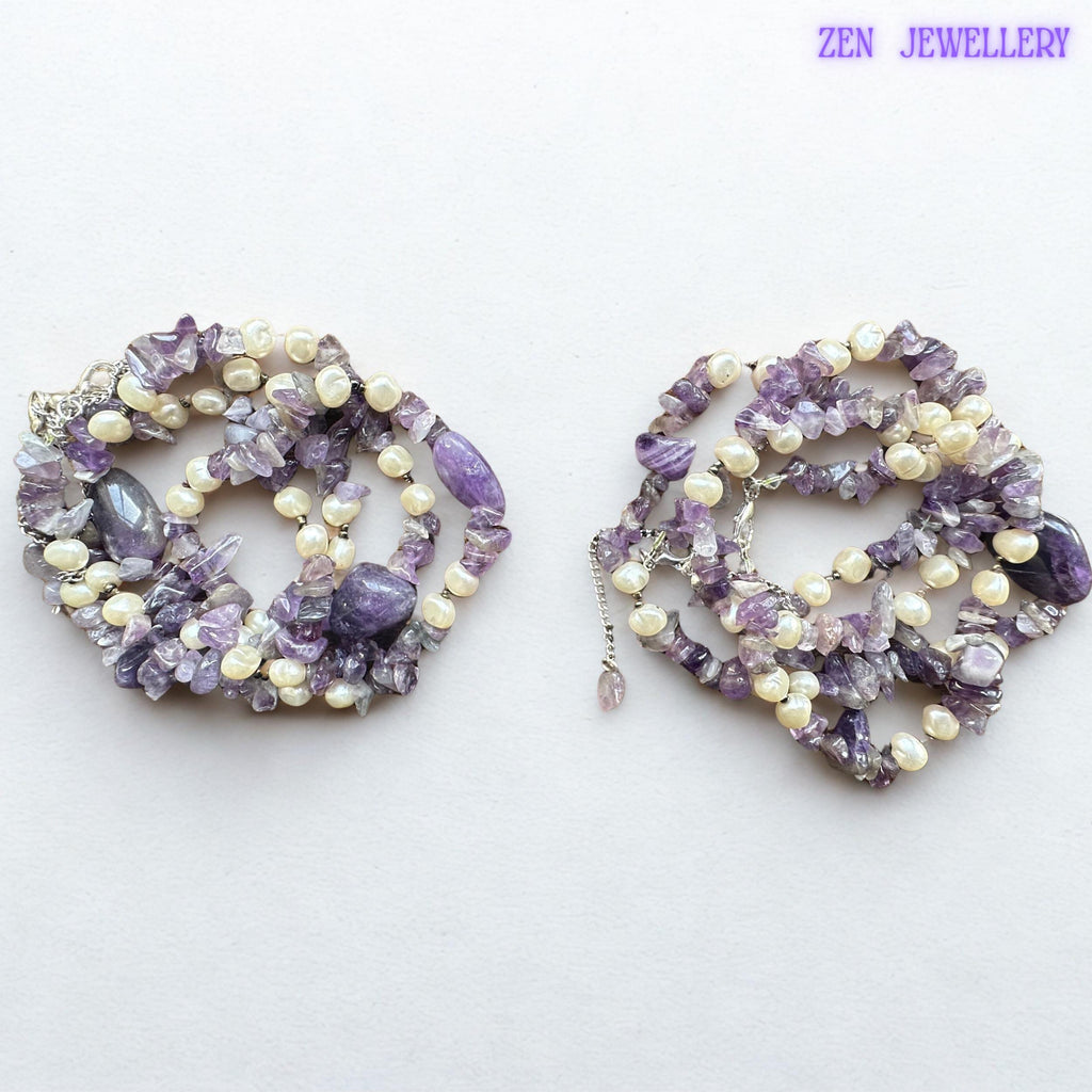 • The necklace features larger polished purple gemstone focal beads surrounded by irregular natural amethyst chips and creamy pearls for an artistic layered effect. The matching bracelet mirrors the same elegant gemstone arrangement to create a coordinated handmade jewellery set.