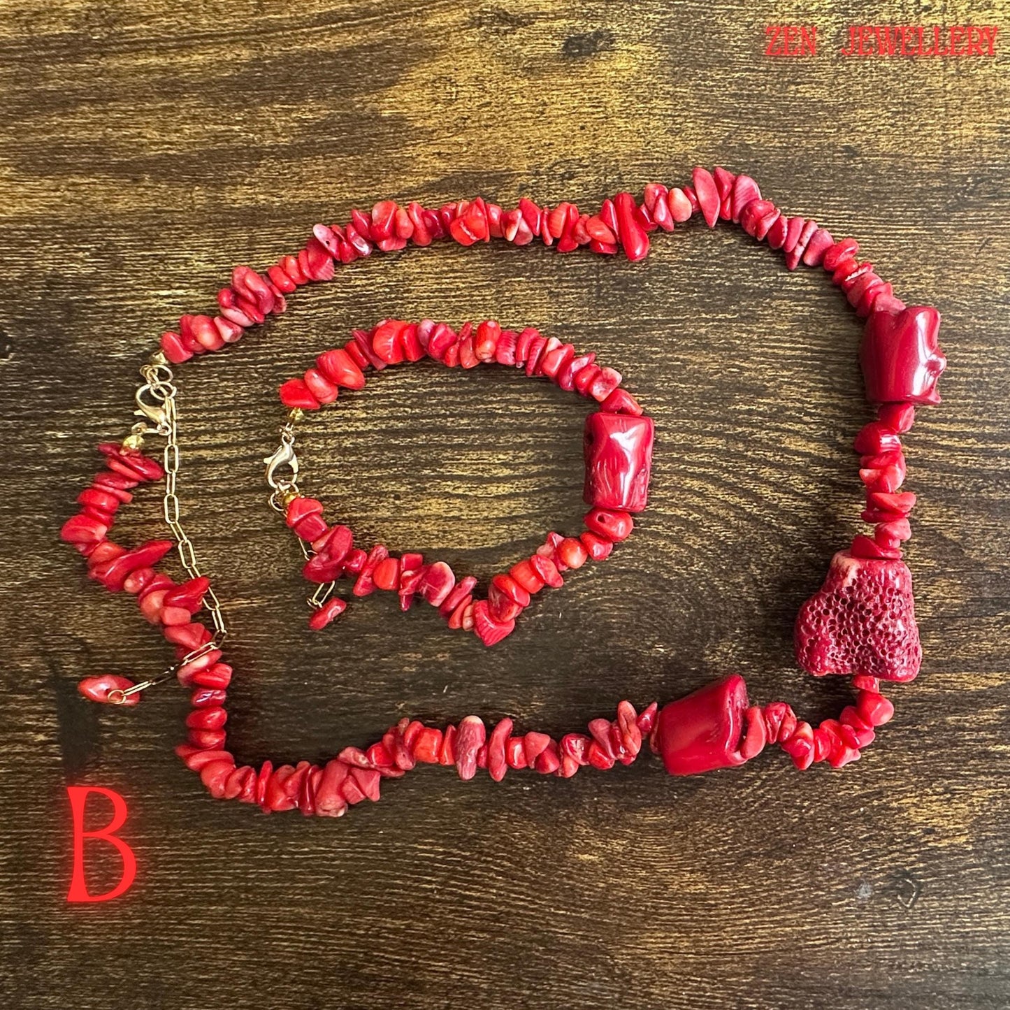 Elegant coral jewellery set photographed on a decorative silver tray to highlight the contrast between vivid red coral chips and warm gold chain details. The handcrafted bead arrangement gives the necklace and bracelet an artisan appearance with movement, texture, and bold visual impact.
