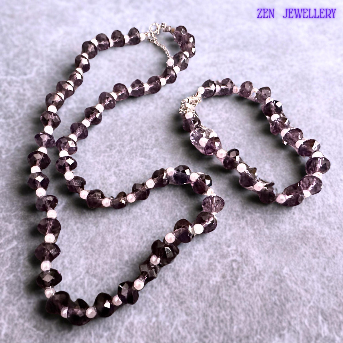 Matching purple crystal bracelet and necklace set designed with faceted lavender beads creating texture sparkle and elegant movement paired with white pearl accents and silver extension chains for adjustable comfortable wear.