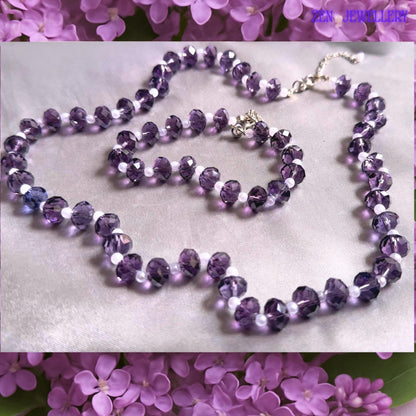 Lightweight handmade jewellery set with sparkling purple crystals and delicate white pearls displayed flat against satin fabric showing the elegant coordinated necklace and bracelet design with polished silver closures.