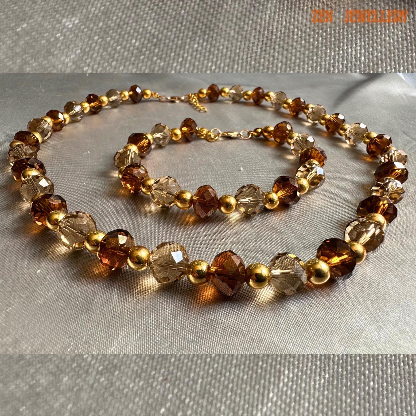 Glamorous handmade necklace and bracelet set featuring faceted amber crystal beads in warm caramel and honey shades combined with metallic gold spacer beads for an elegant evening jewellery look. The jewellery appears lightweight, feminine, and perfect for formal fashion styling or festive occasions.