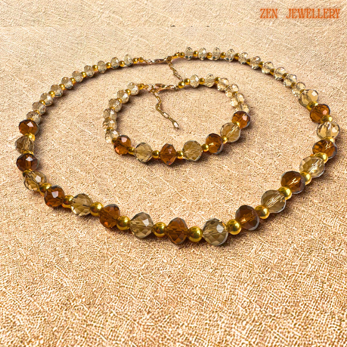 Elegant AUSTRIAN CRYSTAL jewellery set displayed flat on textured black stone to showcase the bead arrangement, reflective crystal textures, gold clasps, and handcrafted design details. The champagne and brown crystals create a warm luxurious palette inspired by autumn and golden evening tones.