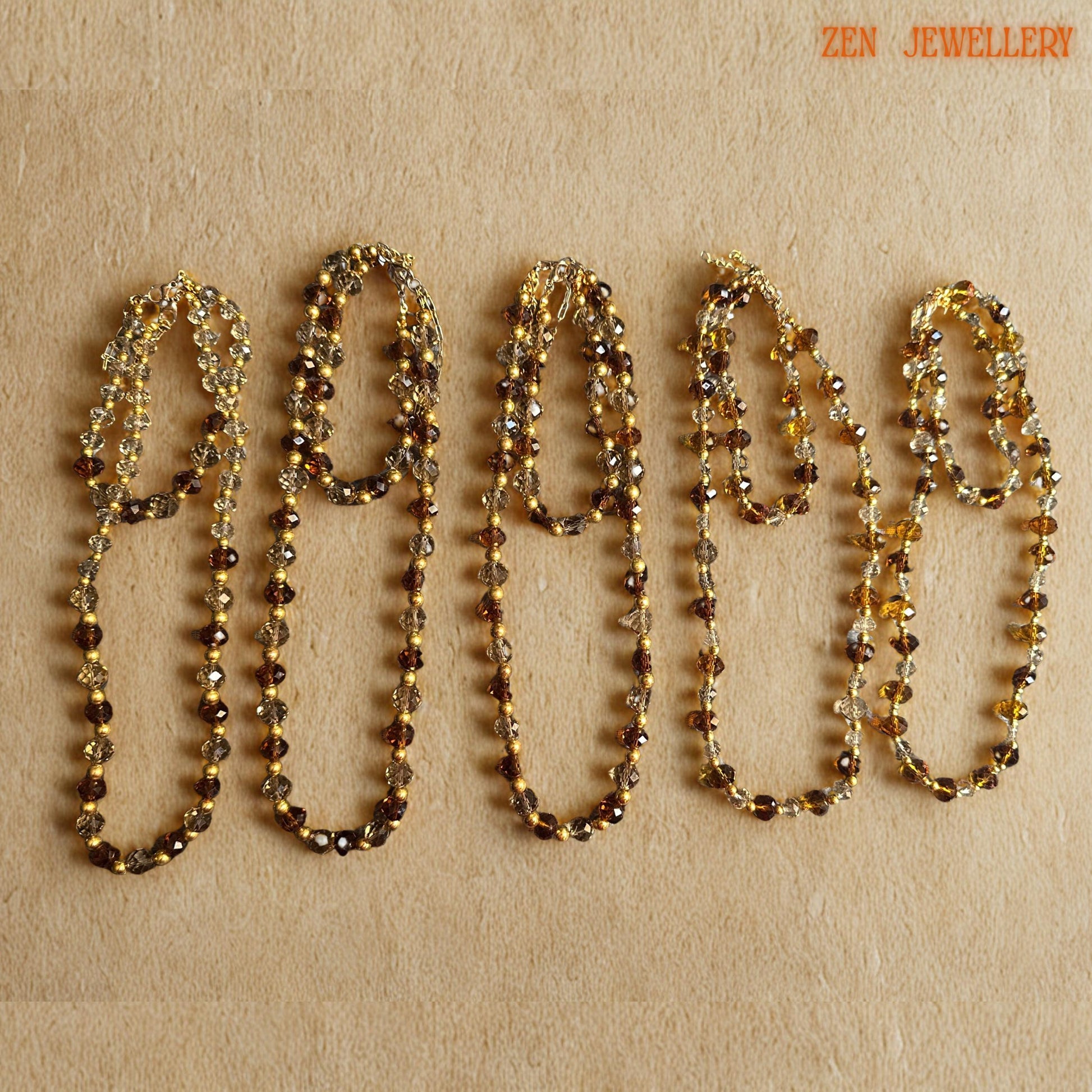 Close-up image of polished faceted AUSTRIAN CRYSTAL beads showing intricate cut surfaces, warm amber reflections, and elegant gold spacer bead details. The necklace and bracelet are carefully handcrafted to create lightweight, comfortable jewellery with luxurious visual sparkle. Elegant caramel crystal necklace paired with matching bracelet featuring golden bead accents and delicate clasp details designed for feminine evening fashion and glamorou