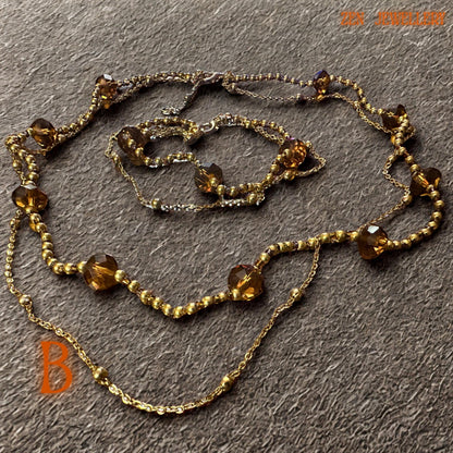 Elegant crystal jewellery set featuring faceted amber Austrian crystal beads combined with delicate gold spacer beads and fine gold chain links. The warm honey tones reflect soft light beautifully and create glamorous sparkle and texture. The handcrafted necklace and bracelet feel lightweight, graceful, and versatile for special occasions or elegant daily wear.