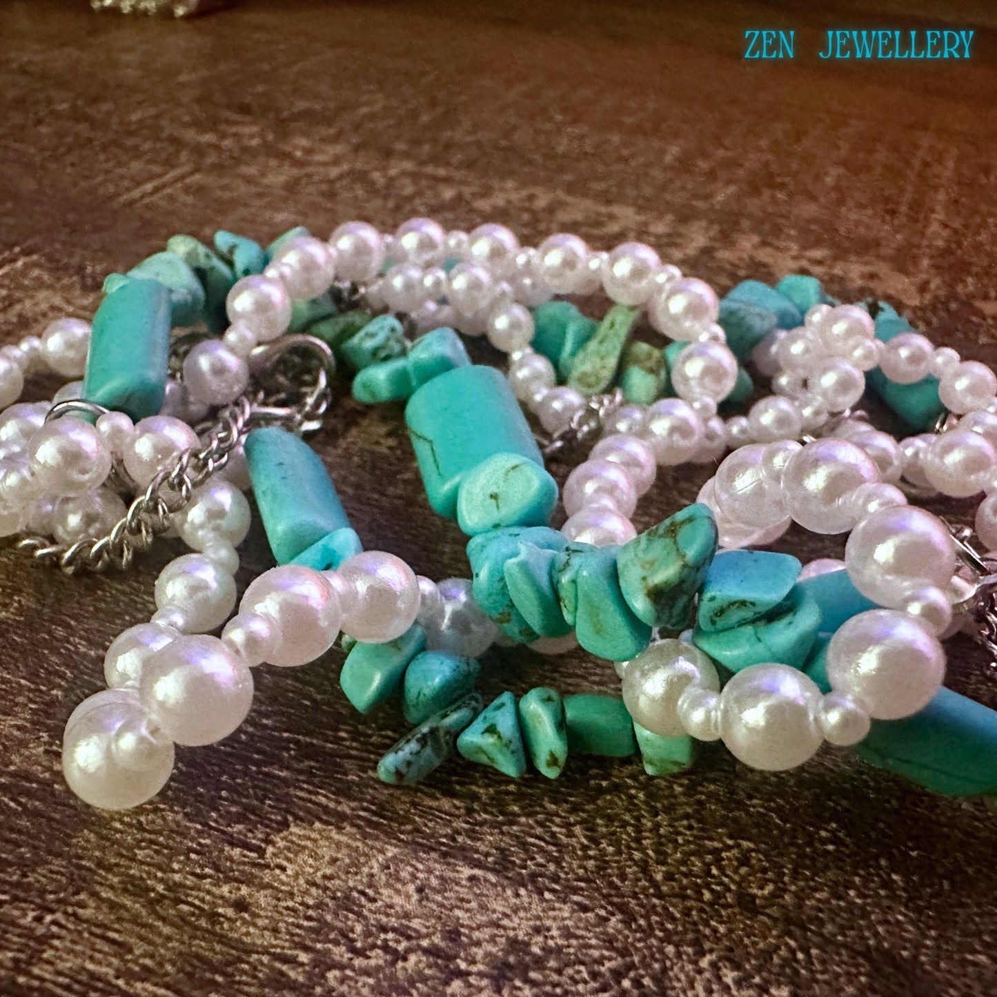 Close-up of the necklace section showing irregular turquoise stones, smooth pearl beads, and polished silver chain details. The layered strand design gives texture, movement, and a handmade boho finish that buyers can see clearly.
