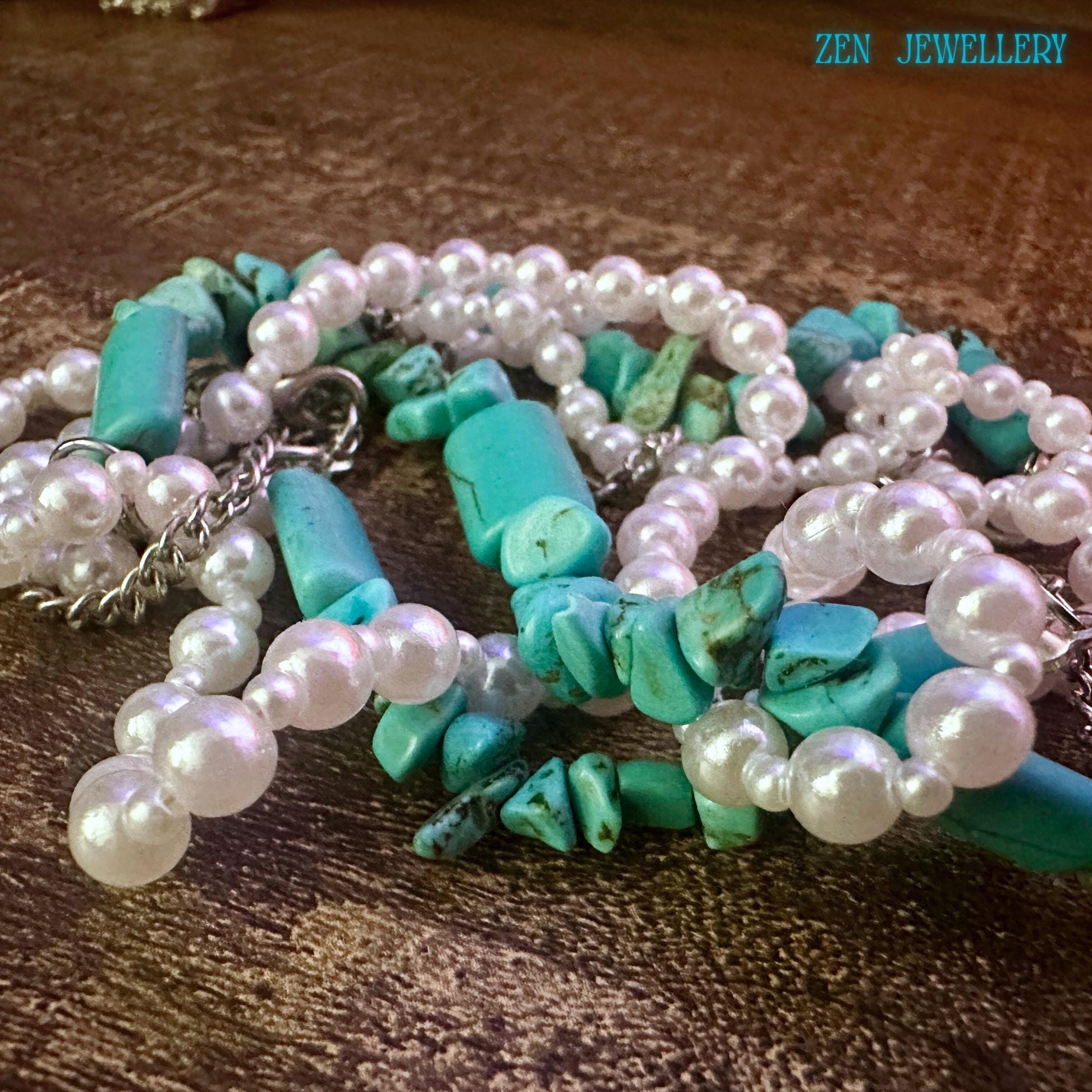 Close-up of the necklace section showing irregular turquoise stones, smooth pearl beads, and polished silver chain details. The layered strand design gives texture, movement, and a handmade boho finish that buyers can see clearly.