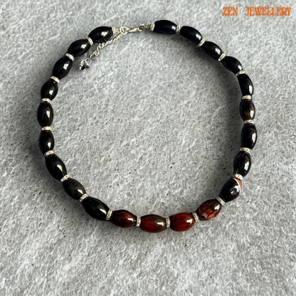 Luxurious AGATE GEMSTONE jewellery necklace featuring polished black oval beads paired with dark burgundy striped agate stones and silver rhinestone spacers. The reflective gemstone surface creates rich shine and dramatic contrast against the soft neutral background. Silver lobster clasp and extension chain allow adjustable sizing and secure wear. Necklace measures approximately 47 cm or 18.5 inches long for comfortable, elegant styling.