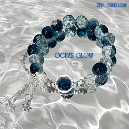 Detailed image focusing on the centrepiece of the bracelet. A round blue gemstone is framed by polished silver-toned metal and surrounded by delicate silver star accents. The celestial details add a magical touch, while the surrounding gemstone beads create a balanced and elegant composition. Adjustable bracelet measuring 19 cm (7.48 inches) for a comfortable fit.