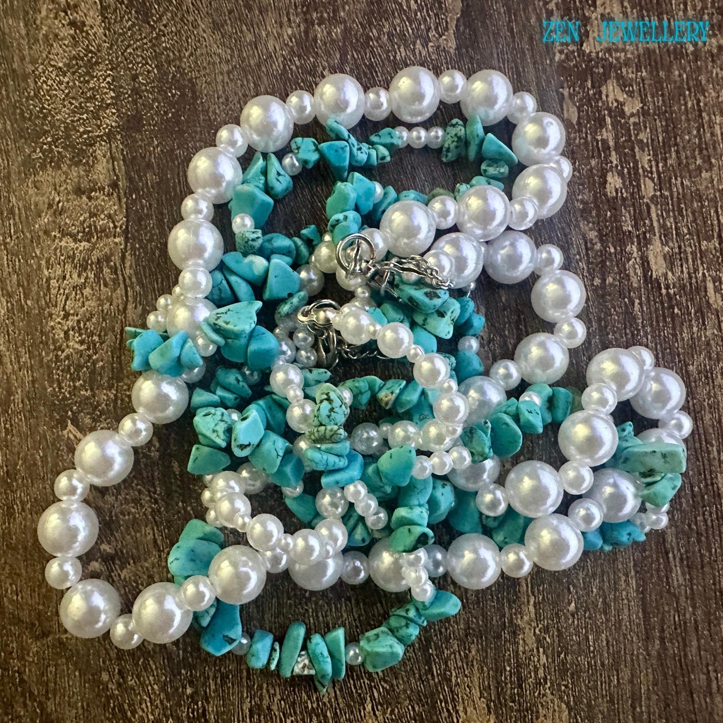 Close-up bead texture showing polished pearls and matte turquoise chips.
Natural wood background enhancing bohemian aesthetic and earthy tones.