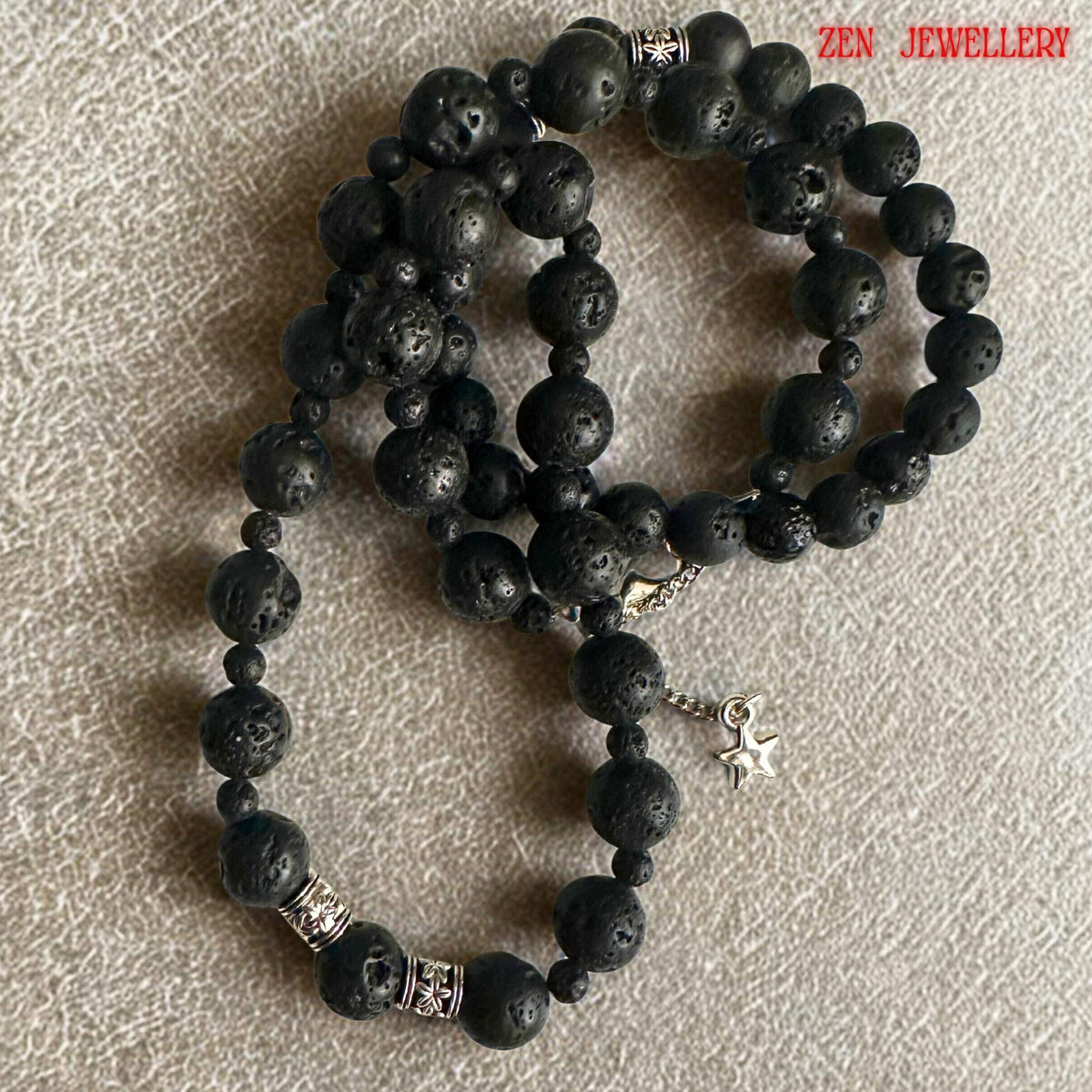Modern bohemian lava stone necklace and bracelet set designed with natural black volcanic beads and silver decorative spacer details. The textured matte stones create a strong earthy appearance while the silver accents add brightness and elegance. The necklace features varying bead sizes for dimension and balance, while the bracelet completes the coordinated minimalist jewellery look.
