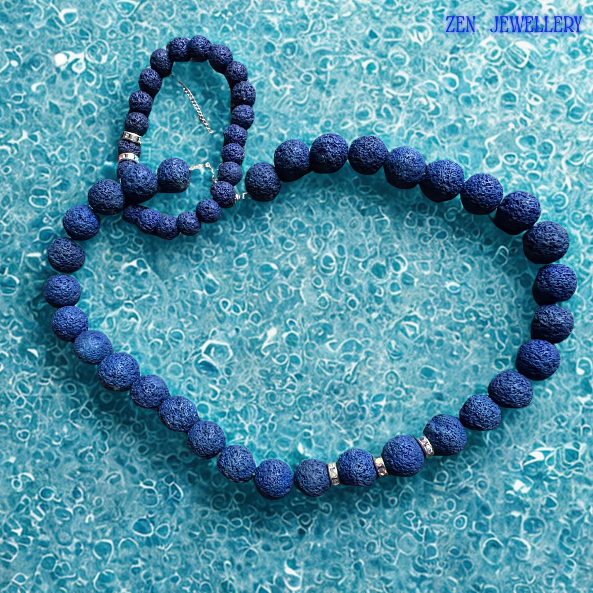 A modern lava stone necklace and bracelet set featuring textured navy volcanic beads in multiple sizes with silver rhinestone spacer accents. The porous stones create depth and natural character, while the matching bracelet complements the necklace perfectly for a coordinated bohemian jewellery look.