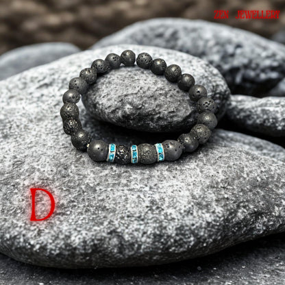 Handmade volcanic bead bracelet photographed in soft natural lighting to highlight the textured lava stones and reflective turquoise rhinestone spacer details. The bracelet has a calming minimalist appearance inspired by spiritual jewellery and grounding volcanic energy.