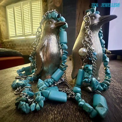 Detailed view of the bracelet from the set displaying two strands of silver chain interwoven with turquoise chips and a small pearl charm, adding elegance and subtle movement to the handmade design.