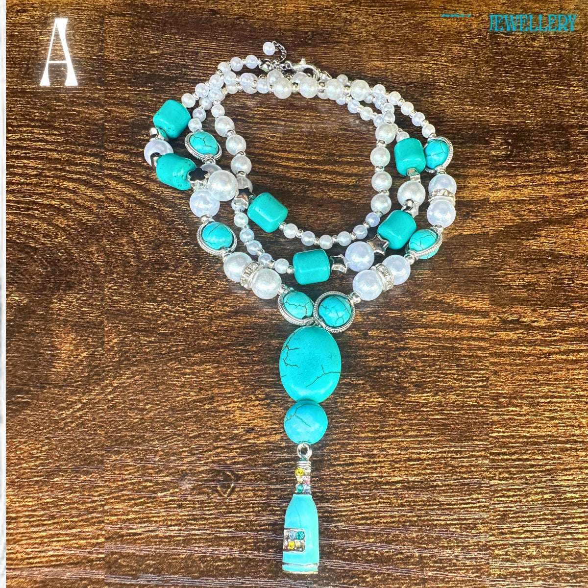 An artistic overhead view of the bohemian turquoise necklace featuring alternating pearl beads and turquoise chips connected with sterling silver spacers. The museum-quality turquoise centrepiece displays natural stone cracks and textures, adding authenticity and character. The soft pearl sheen contrasts beautifully with the bold turquoise tones, creating an eclectic jewellery set perfect for boho fashion lovers.