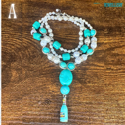 An artistic overhead view of the bohemian turquoise necklace featuring alternating pearl beads and turquoise chips connected with sterling silver spacers. The museum-quality turquoise centrepiece displays natural stone cracks and textures, adding authenticity and character. The soft pearl sheen contrasts beautifully with the bold turquoise tones, creating an eclectic jewellery set perfect for boho fashion lovers.