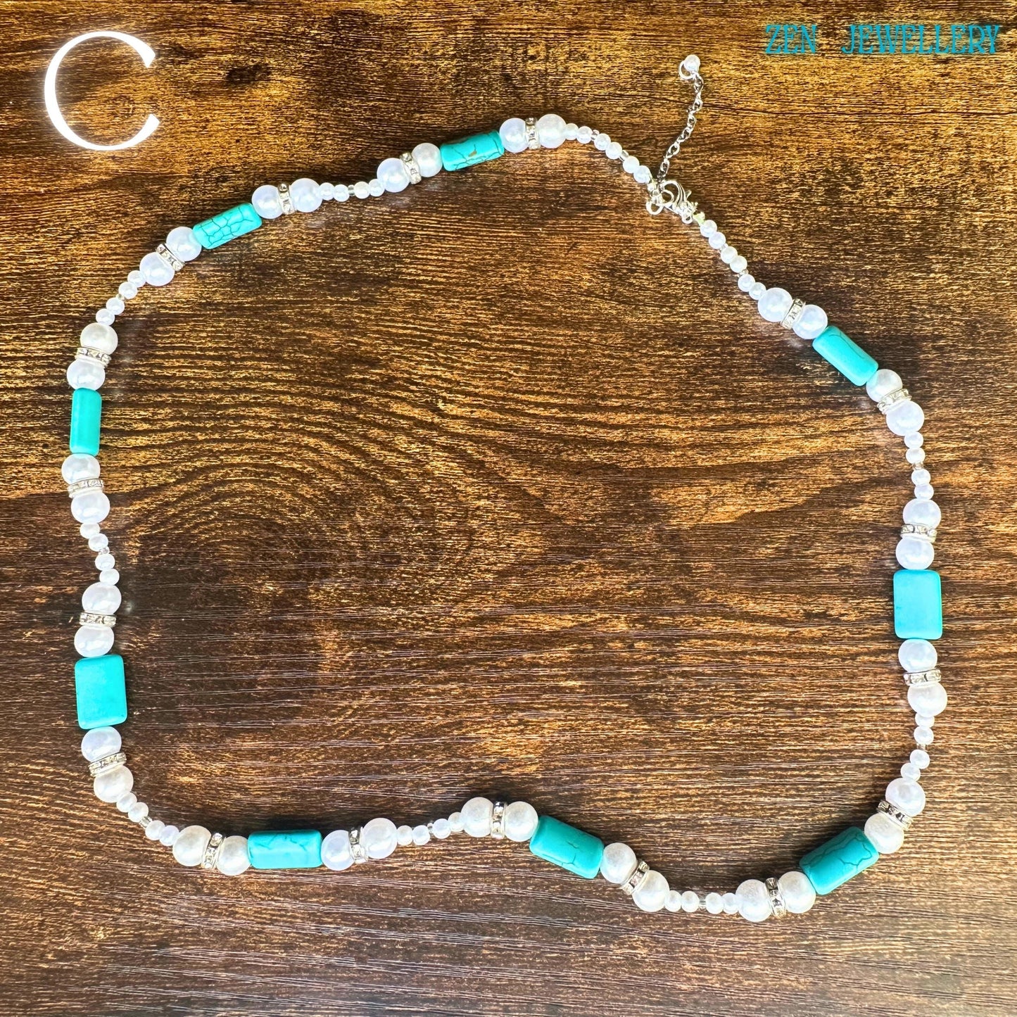 A luxury bohemian necklace arrangement featuring turquoise chip jewellery details, combined with pearl elegance and sparkling rhinestone accents. The necklace displays smooth, round beads, chunky turquoise focal stones, and silver decorative rings surrounding turquoise cabochons. The artisan craftsmanship and vintage western style make this piece perfect for collectors of handcrafted turquoise jewellery.