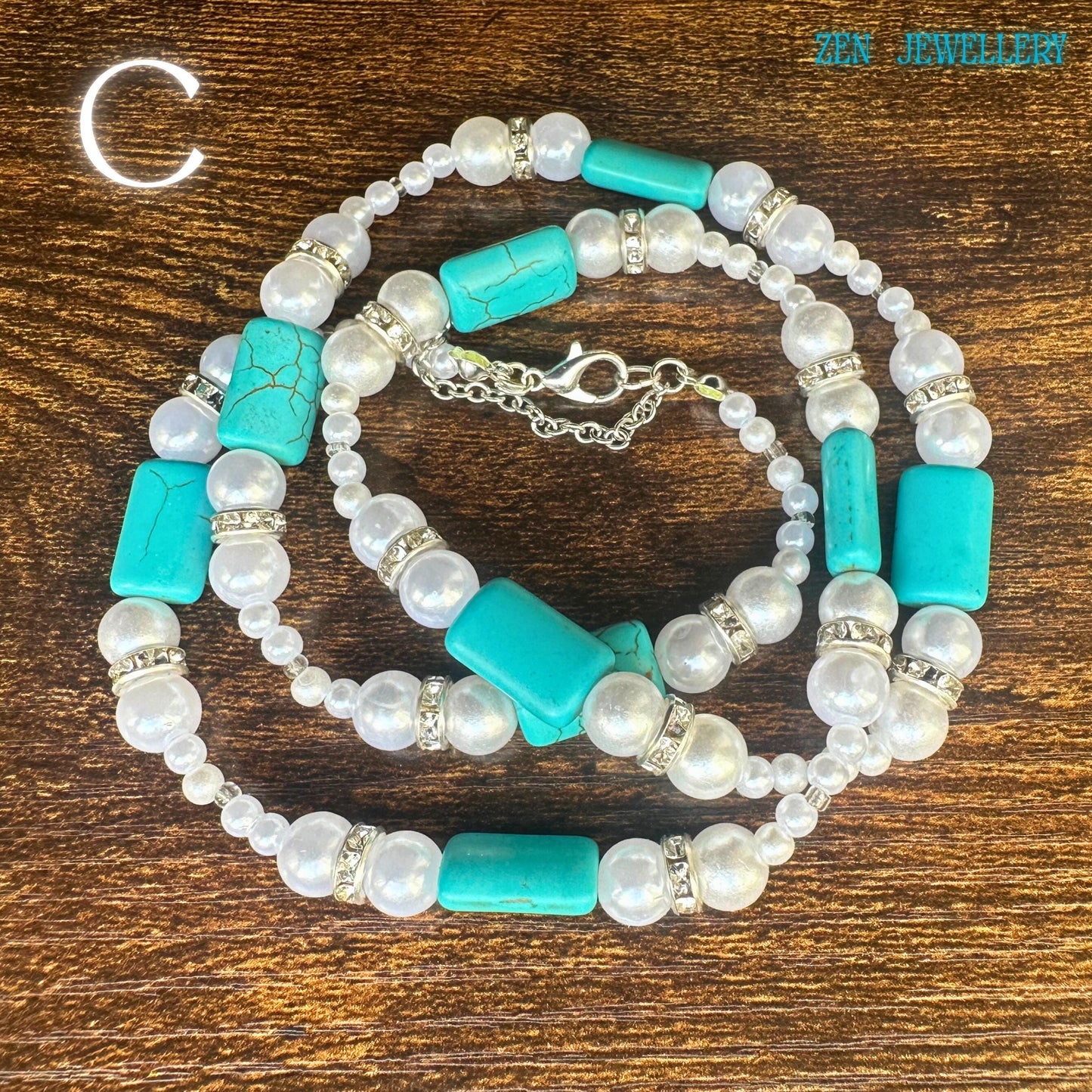 A carefully styled image of the vintage turquoise necklace resting across a wooden background, revealing its long, elegant silhouette and handcrafted gemstone arrangement. The pearls create softness while the turquoise stones introduce bold natural colour. Decorative silver accents frame several turquoise beads, adding depth and texture. The necklace's length allows versatile styling for layered boho looks.