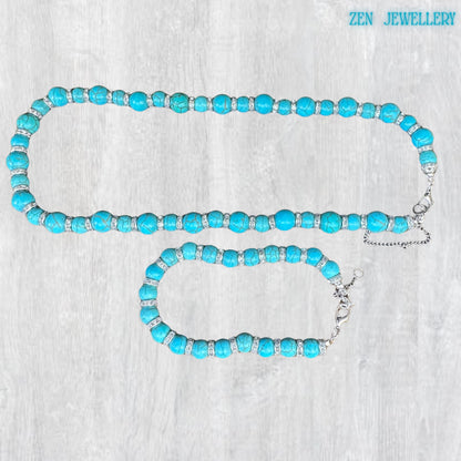 A luxury boho chic jewellery set featuring vivid turquoise beads with silver rhinestone accents arranged in a balanced handcrafted design. The matching bracelet and necklace combination creates a stylish, coordinated accessory set ideal for women who love artisan turquoise jewellery and elegant statement pieces.
