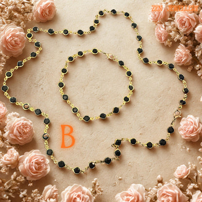 Sophisticated black crystal jewellery set featuring glossy faceted jet black stones framed in gold-tone settings with elegant chain connections. The minimalist design creates dramatic contrast against the soft neutral floral background and highlights the timeless elegance of the handcrafted necklace and bracelet set. Lightweight yet striking, this versatile accessory works beautifully with modern fashion, gothic chic outfits, evening wear, or eve
