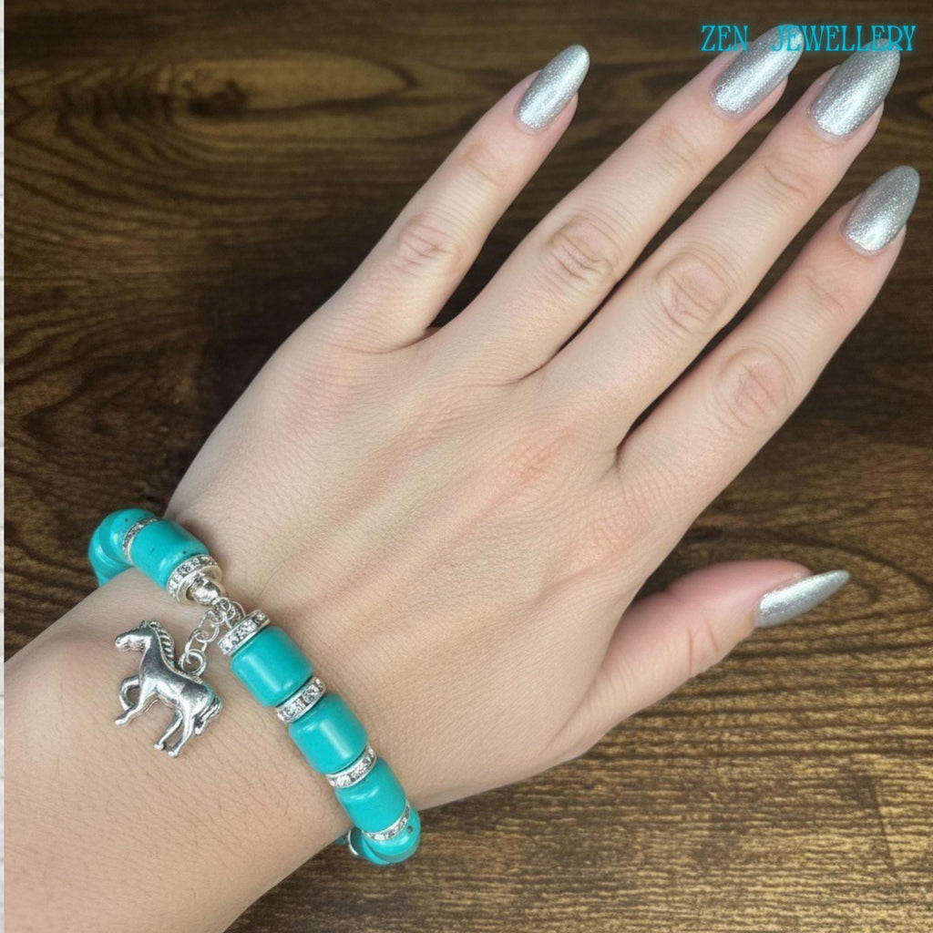 Close-up view of a turquoise bracelet with smooth glossy turquoise barrel beads and silver rhinestone spacer accents arranged evenly around the bracelet for an elegant and balanced handmade jewellery design.