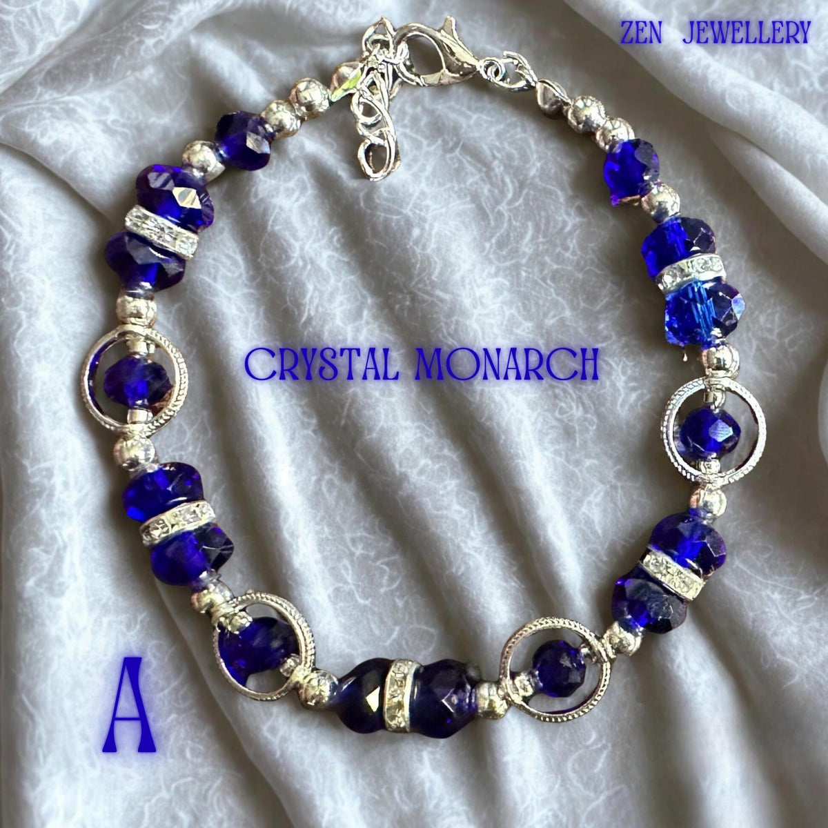 Detailed angle showing the bracelet arranged in a circular shape to showcase the complete handcrafted design. Deep cobalt and royal blue crystal beads alternate with polished metallic accents, creating a sophisticated colour palette. Sparkling rhinestone rondelles add luxury and brilliance between larger crystals. The silver-tone lobster clasp and extension chain allow adjustment beyond the 17cm bracelet length, making it suitable for a variety o