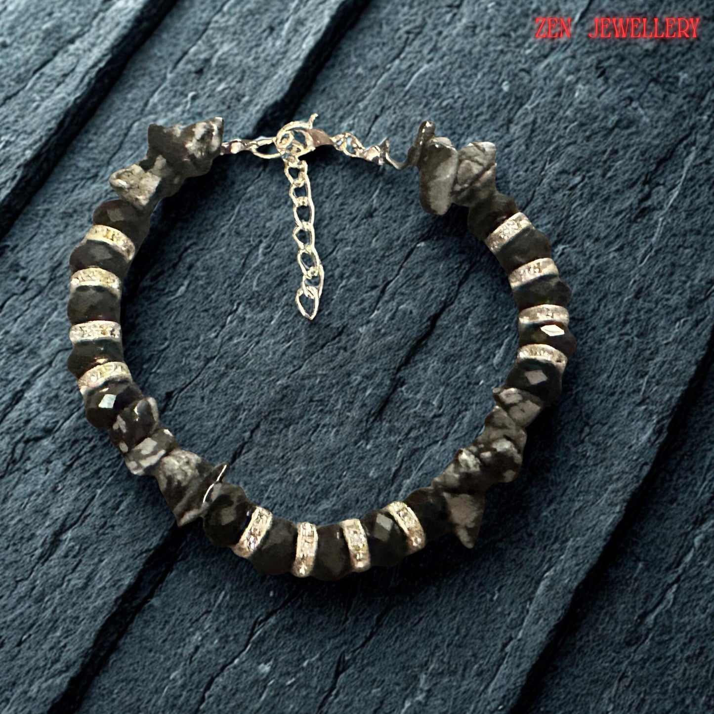 Bracelet photographed on a wrist to provide scale and styling inspiration. The layered design wraps gracefully around the wrist, showcasing the combination of black crystal beads, grey gemstones, rhinestone spacers, and silver details. Adjustable length ensures a comfortable and versatile fit.