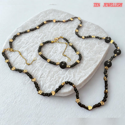 Several larger round black agate beads serve as focal elements within the necklace and bracelet design. These statement stones add depth, dimension, and luxury while maintaining a cohesive appearance with the smaller surrounding beads. The photograph captures the smooth rounded shapes and glossy finish of the gemstones, allowing buyers to visualize the premium quality and elegant character of the handcrafted jewellery.