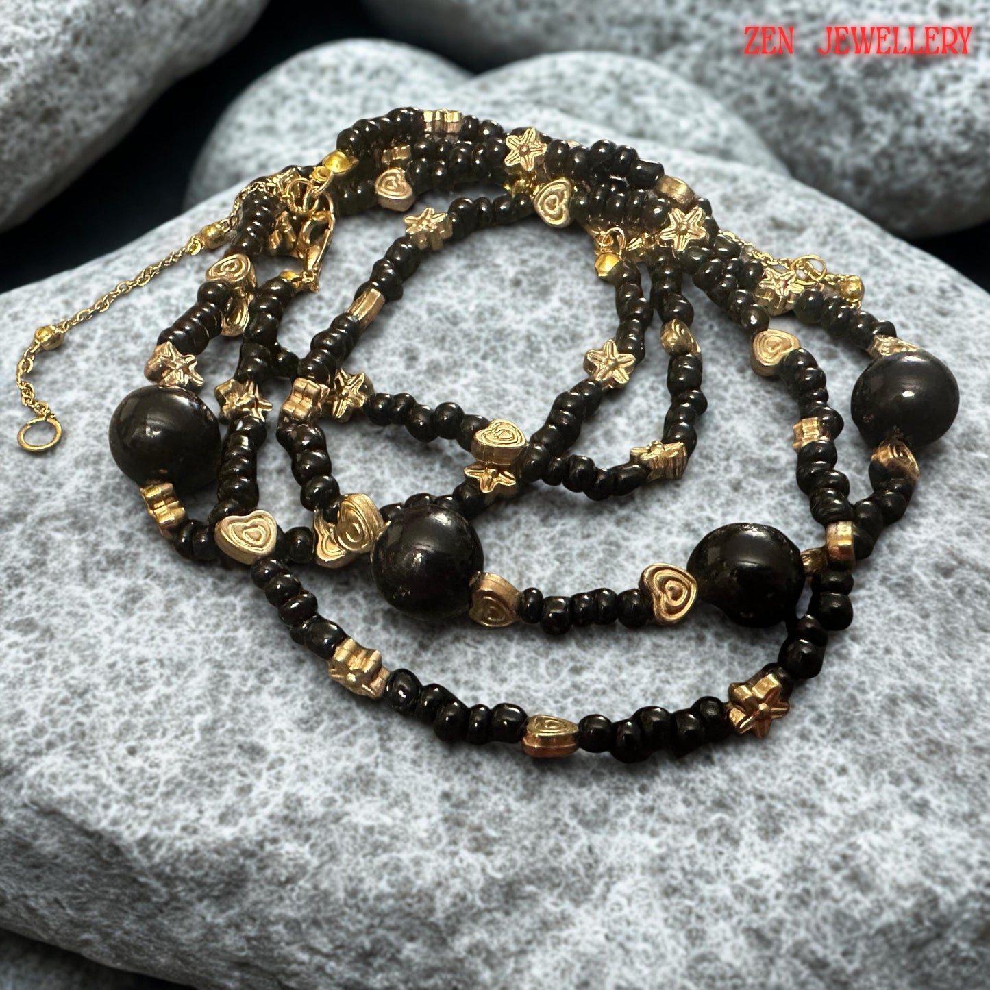 The arrangement of the necklace highlights the flowing pattern created by alternating black agate beads, floral spacers, and heart accents. This carefully balanced composition demonstrates the attention to detail involved in the jewellery's construction. Buyers can clearly observe the consistency of the design and the harmonious distribution of decorative elements throughout the necklace.