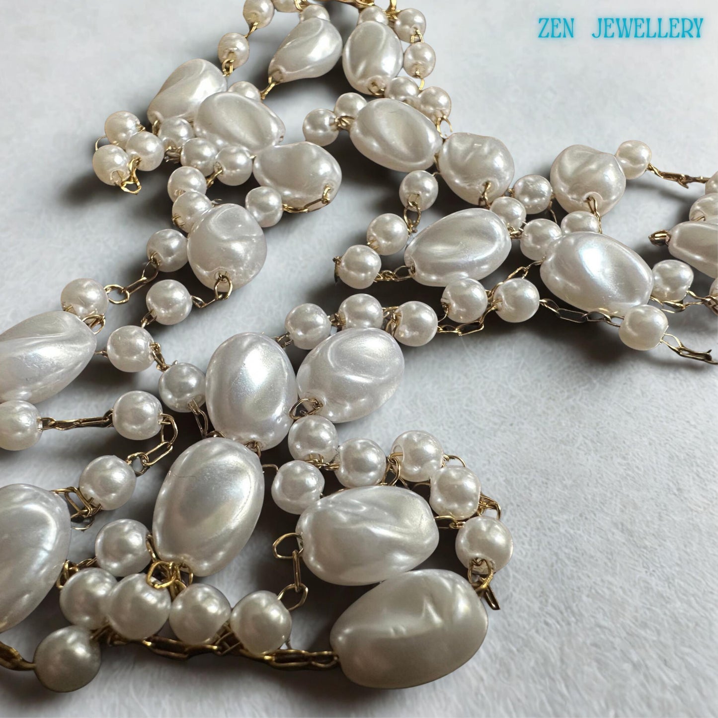 The white pearl necklace features oval beads spaced between tiny round pearl-style beads connected with delicate gold chain accents. The airy layered design creates graceful movement and a lightweight elegant appearance. The handmade necklace pairs beautifully with bridal outfits, wedding guest dresses, or everyday feminine styling.