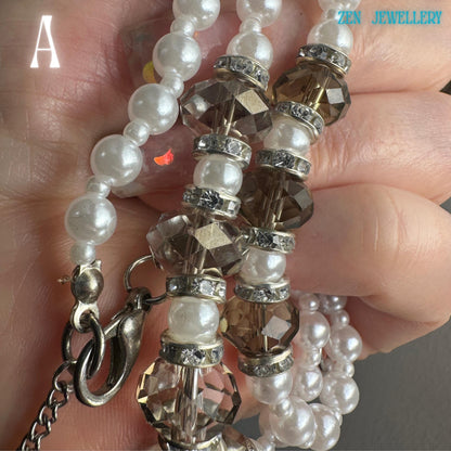 Close view of white pearl necklace featuring sparkling Austrian glass crystals and rhinestone spacers that add shimmer and texture between the smooth round pearls. Silver rhinestone spacers separate the beads and create a refined sparkling effect. The bracelet mirrors the necklace design for a coordinated and polished jewellery look. The handmade style feels romantic, graceful, and timeless with soft, feminine tones and delicate silver details.