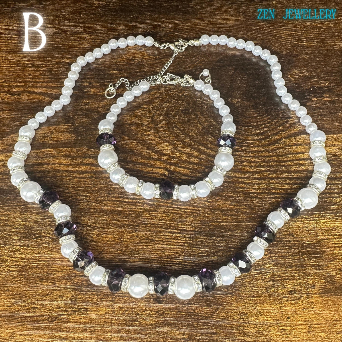 Elegant white pearl necklace and bracelet set with faceted Austrian transparent and purple glass beads and rhinestone spacers on a dark wooden textured background. Delicate pearls create a classic luxury jewellery look. The glossy surfaces of the beads reflect light softly while the faceted crystals add sparkle and depth. The elegant colour palette creates a calm and luxurious appearance perfect for weddings or special occasions.