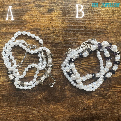This handmade necklace and bracelet set combines delicate white pearl-style beads with faceted crystal accents and polished silver details. The jewellery has a balanced and flowing layout with alternating bead sizes for added texture and depth. The glossy pearls create a soft romantic aesthetic while the crystal beads add elegant sparkle. The matching bracelet complements the necklace perfectly and creates a graceful coordinated jewellery set sui