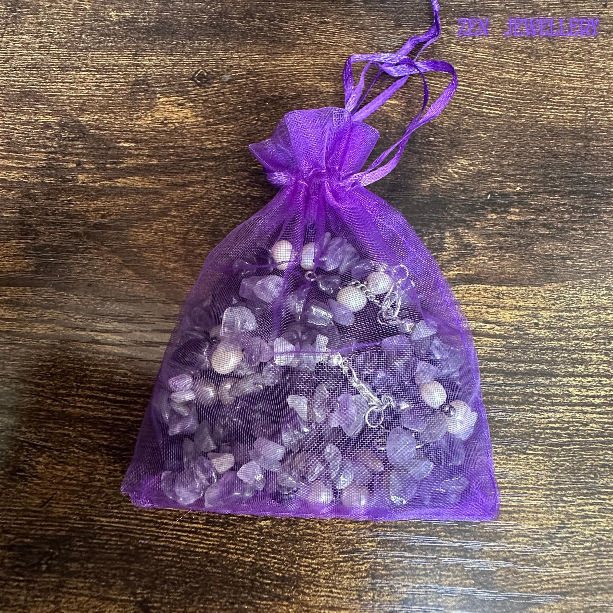 A close image focuses on the healing jewellery materials, showing the smooth stones and polished silver chain in a gift bag